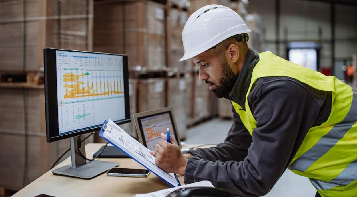 Worker calculating inventory stock on a spreadsheet